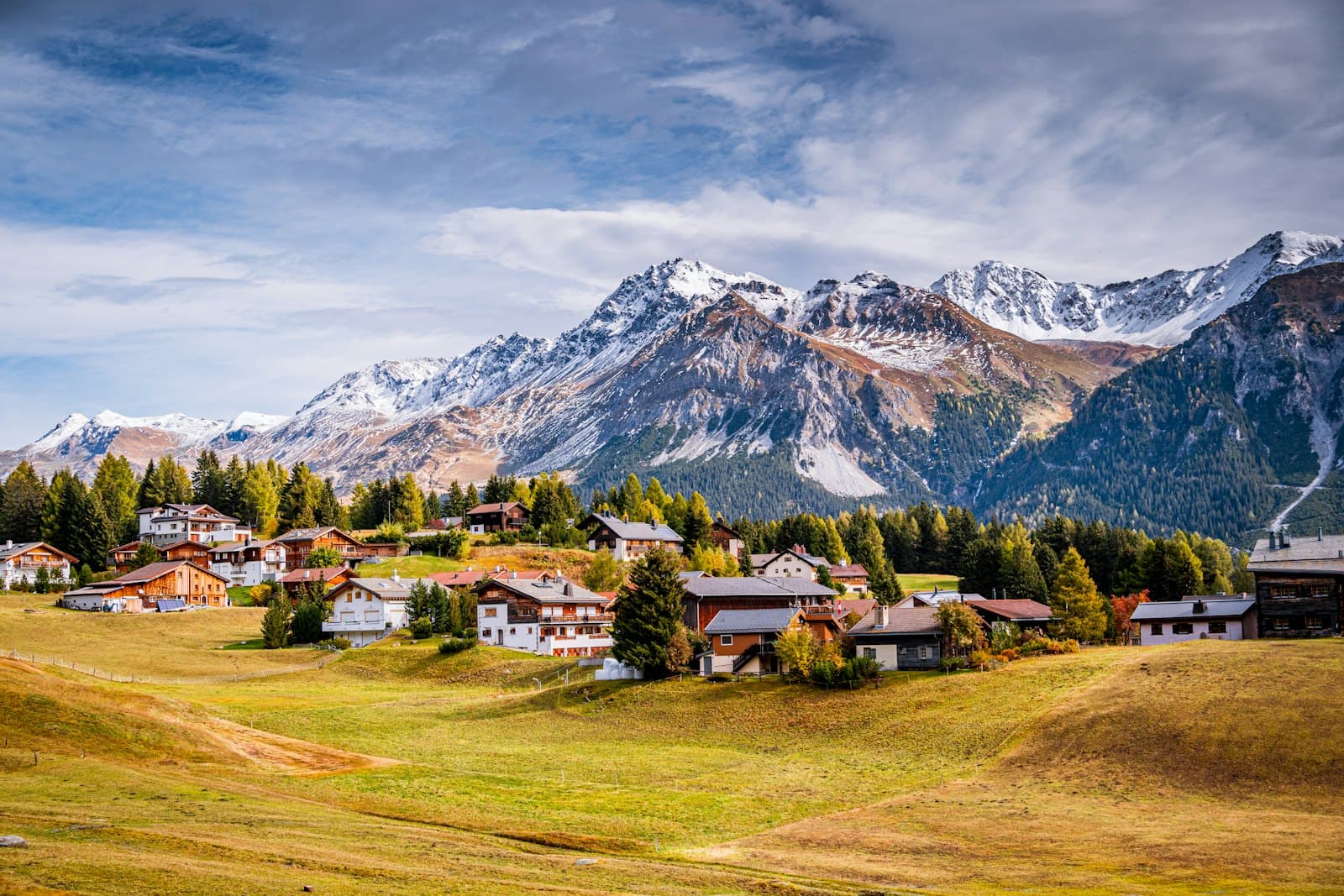 An Alpine village below snow-capped peaks