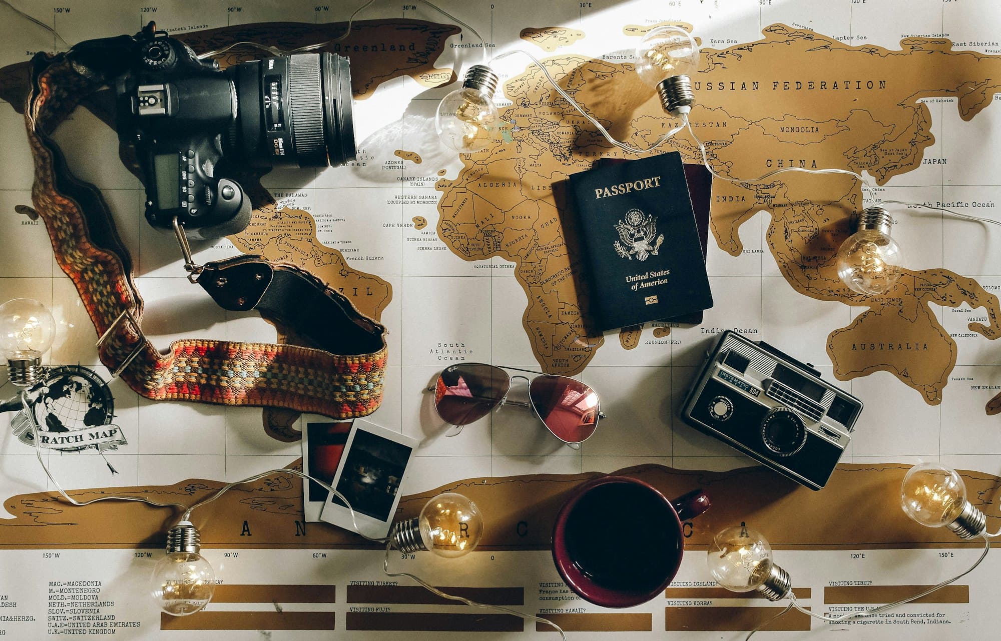 A camera, passport and world map laid out for trip planning