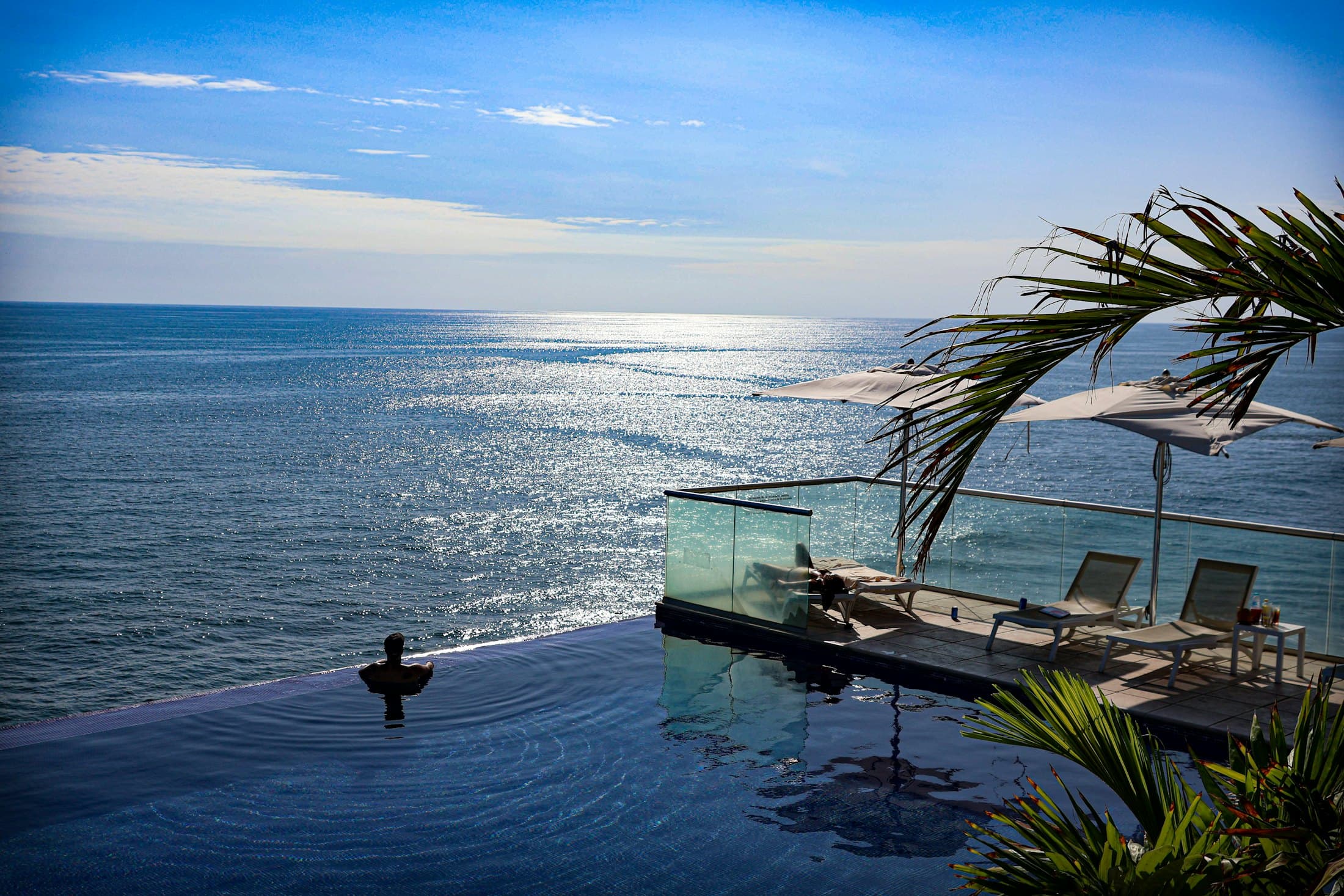 An infinity pool merging into the ocean at a luxury resort