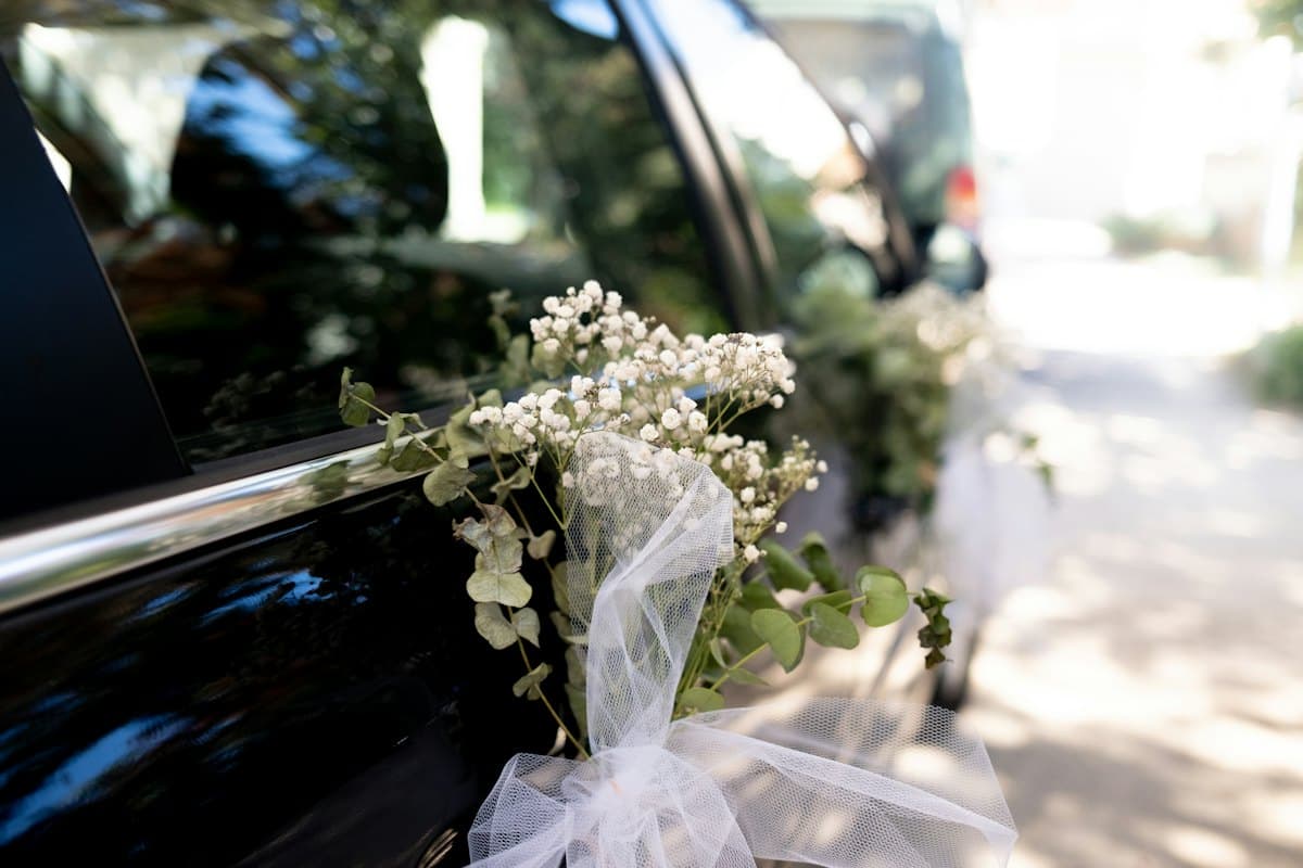 A wedding car decorated with white flowers